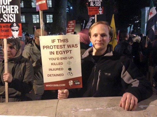 أحد المتظاهرين في لندن ضد قائد الانقلاب  يرفع لافتة كتب عليها : "لو كانت هذه التظاهرة في مصر لكنت مقتولًا أومصابًا أو معتقلًا"
